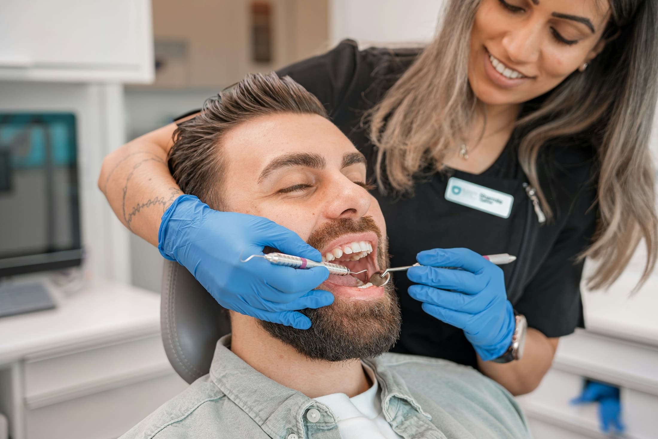 A dentist and dental assistant examining a patient during a routine check-up