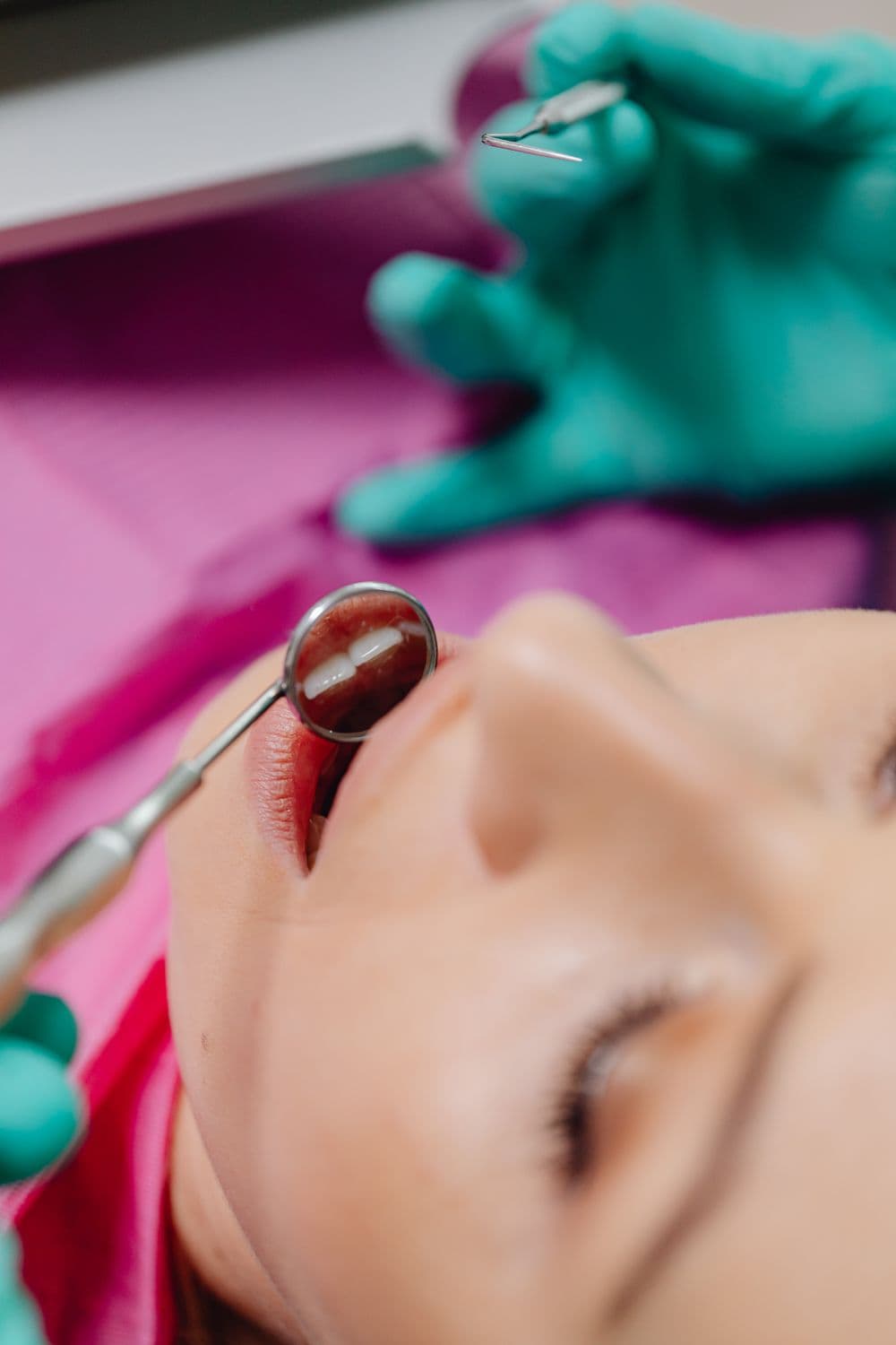 A dentist examining a patient's mouth during assessment of a dental concern