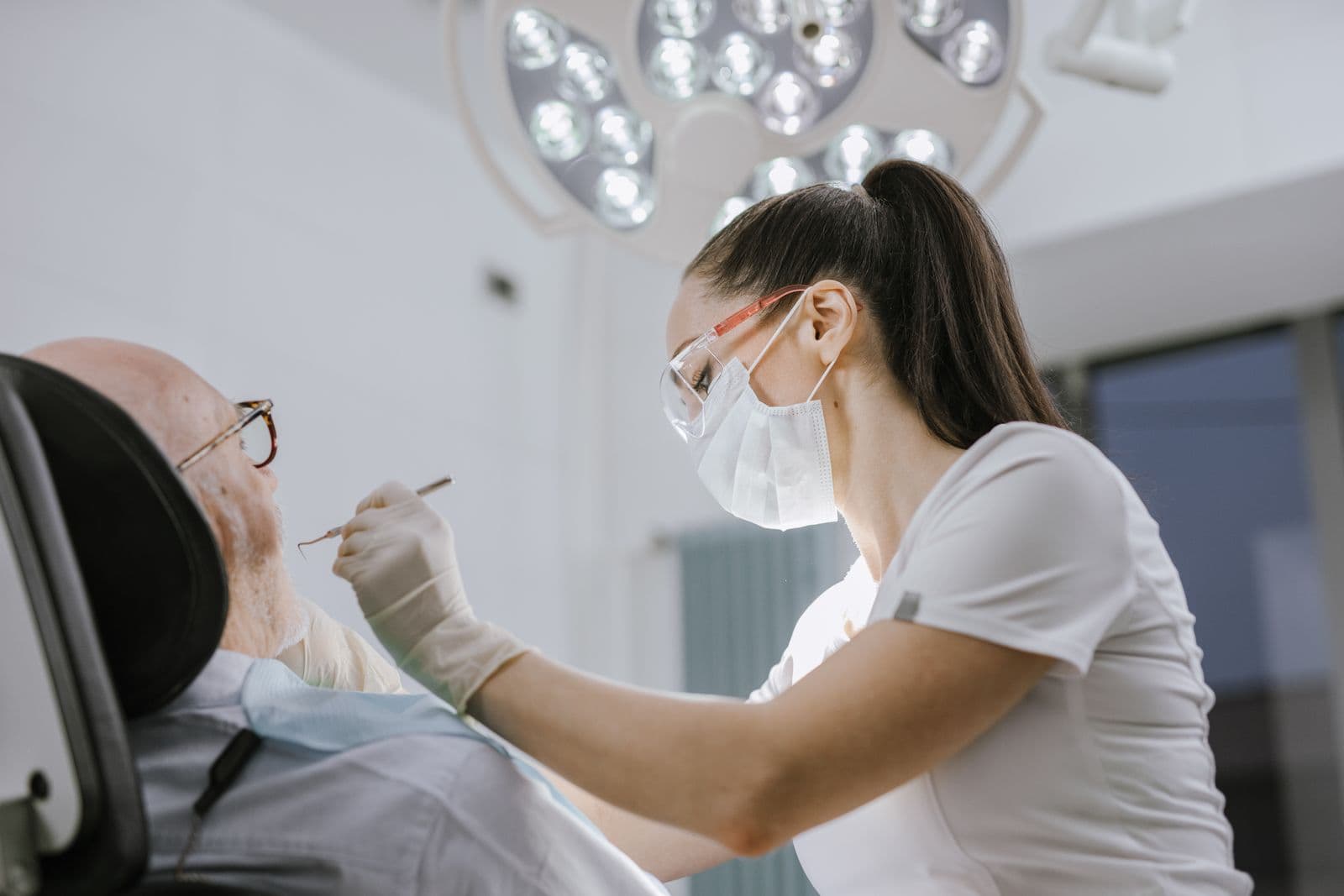 A dentist examining an older patient's teeth during a check-up