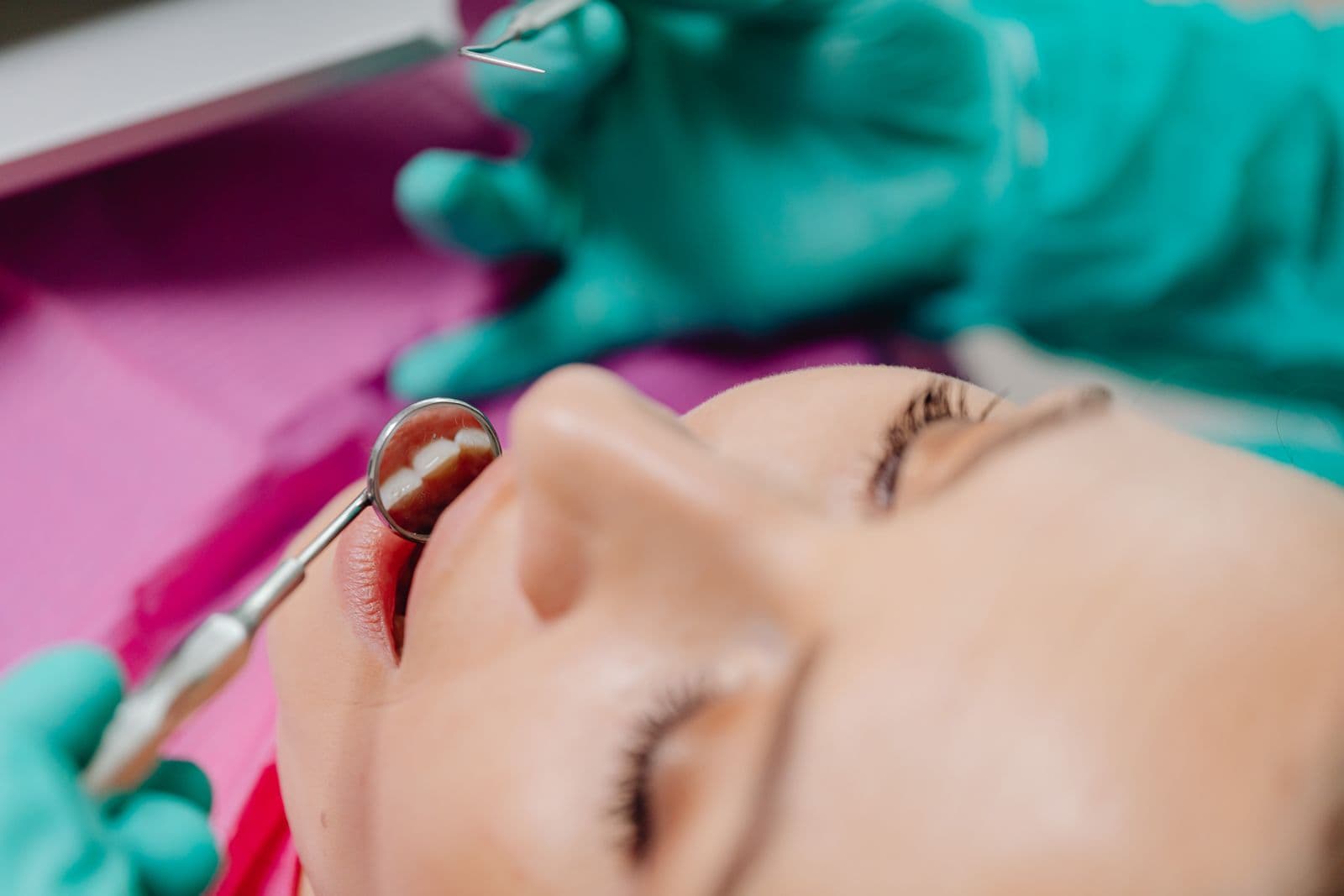 A dentist using a small mirror to examine a patient's front teeth
