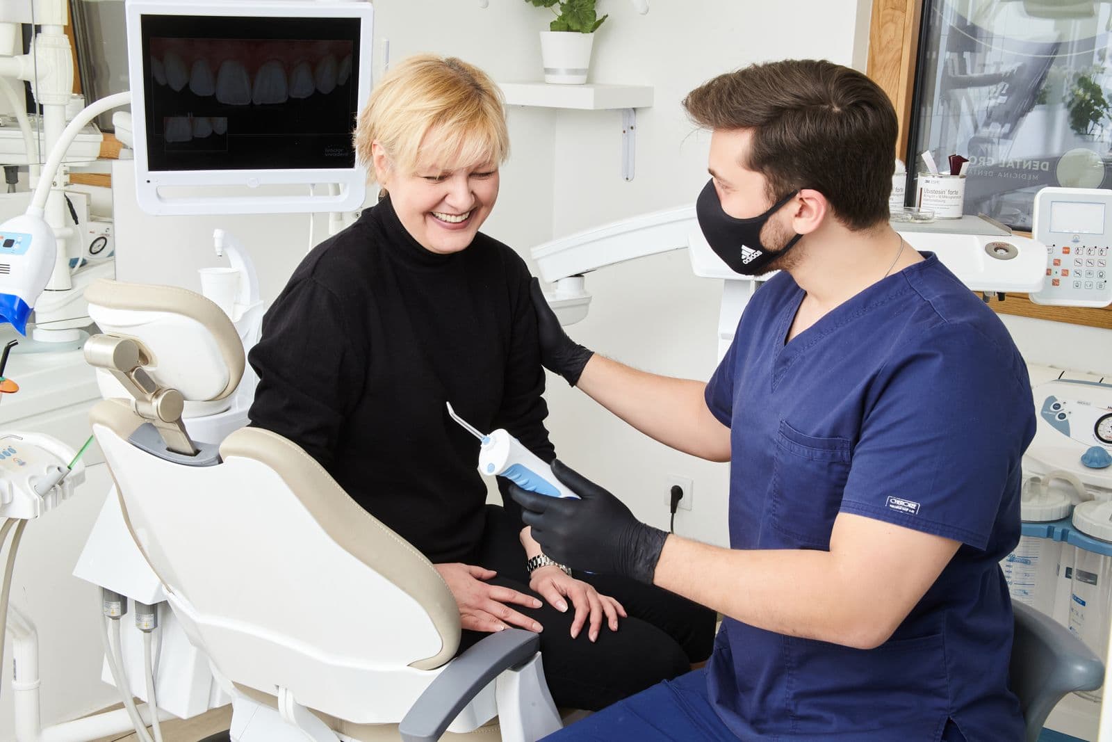 A smiling patient talking with her dentist during a consultation